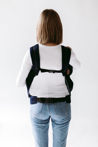 Frau trägt Zwillinge in Weego TWINS Babytragesack. Rückansicht.