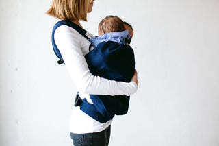 Frau trägt Zwillinge in Weego TWINS Babytragesack. Seitenansicht.